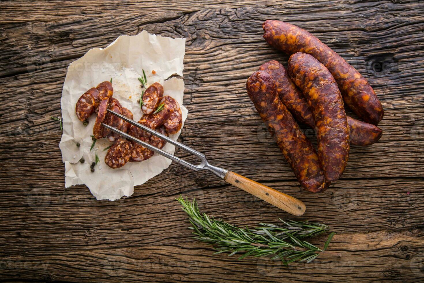 Sausages. Smoked Sausages. Chorizo sausages with vegetable rosemary spices and kitchen utensil. photo
