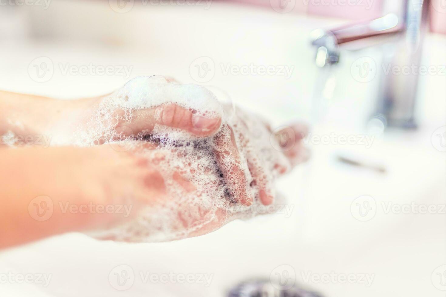 Washing hands with water and liquid soap in the bathroom. Hygiene anti-virus concept photo