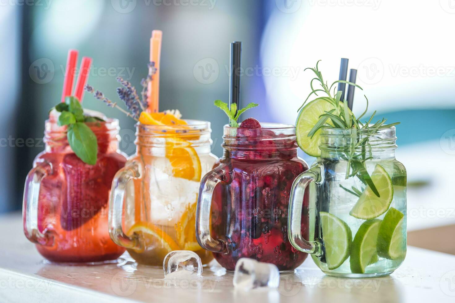 Various lemonades in mason jars with orange lime lemon otange strawberries and fresh fruit fruits photo