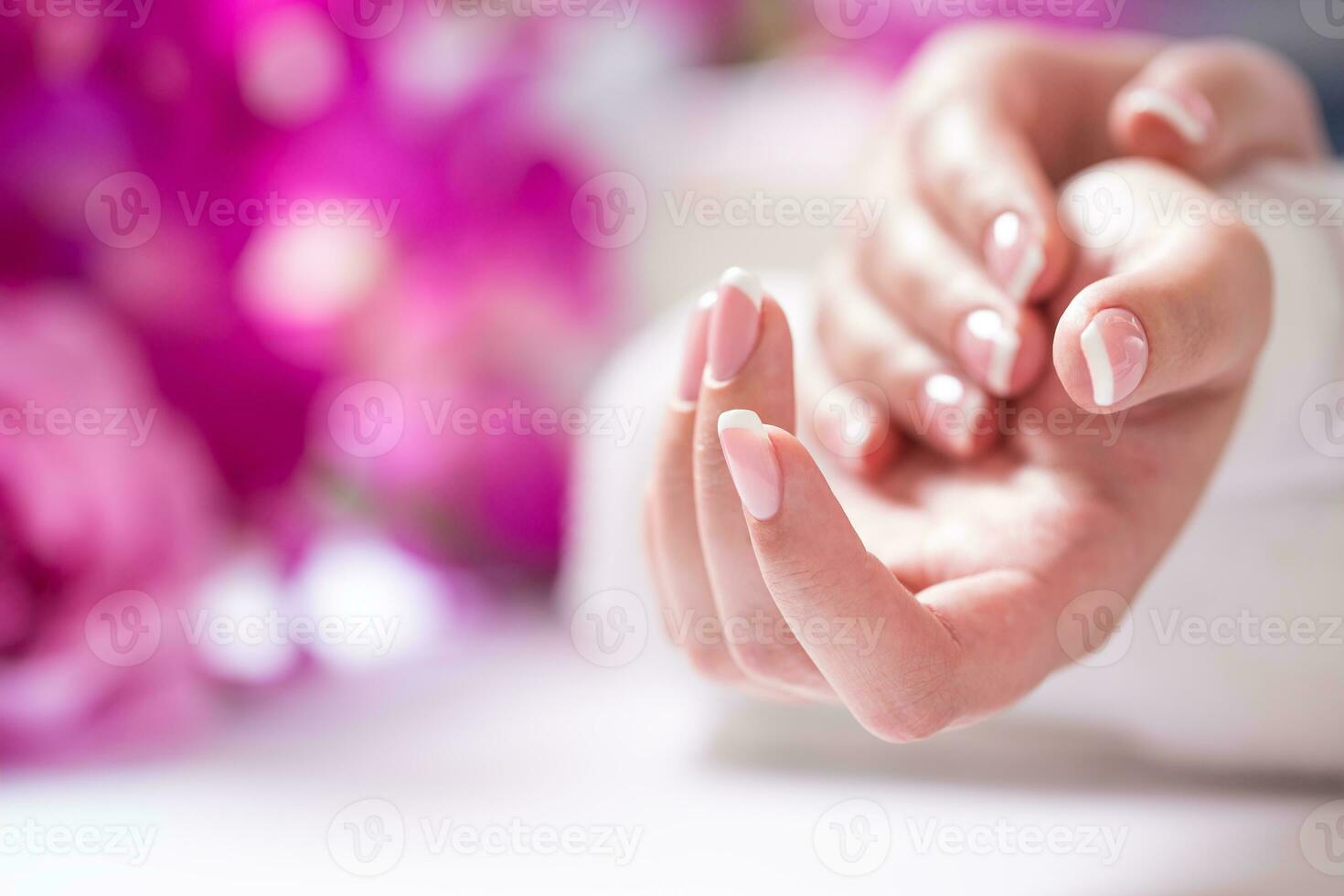 Closeup shot of beautiful female dands with nails of france manicure. Manicure and spa concept photo