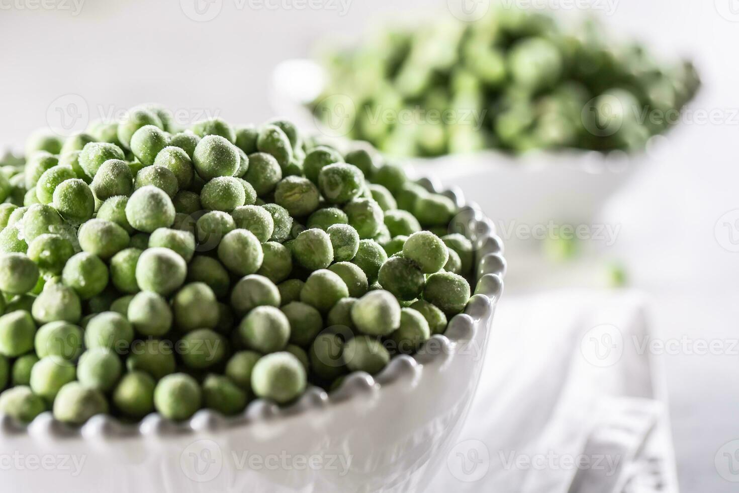 Frozen peas in a white porcelain bowl. photo