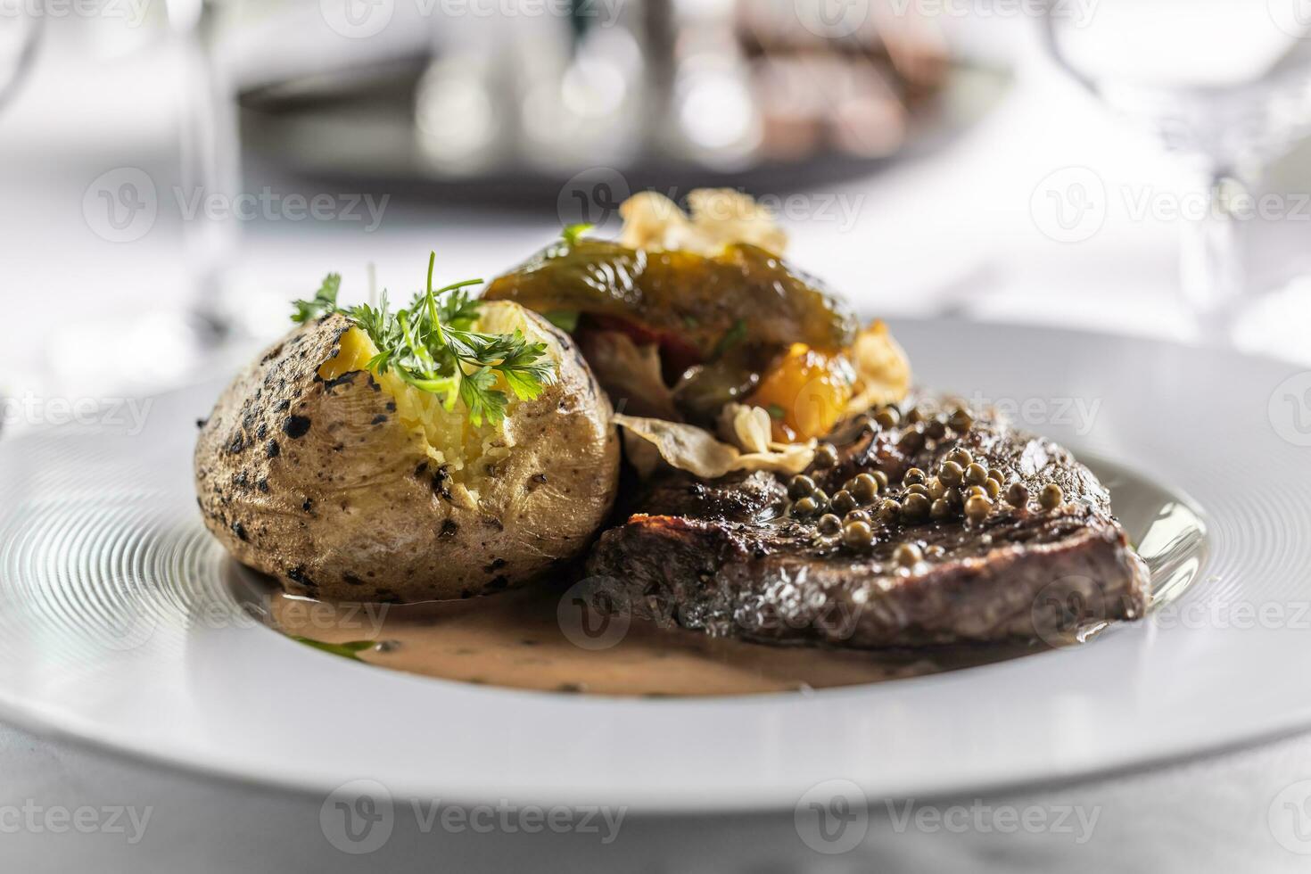 bien hecho costilla ojo filete detalle en un plato con horneado patata y perejil como un decoración foto