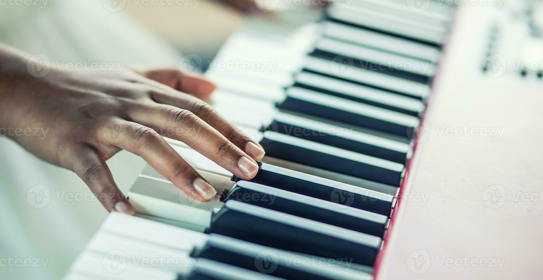 Close-Up a black woman hands playing on piano photo