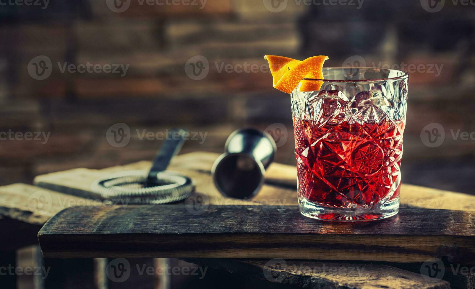 cóctel negroni en un antiguo de madera tablero. bebida con Ginebra, Campari martini rosso y naranja foto