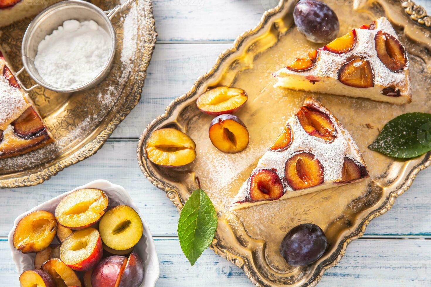 Homemade plum cake in vintage plate on wooden table. Plums pie with sugar powder photo