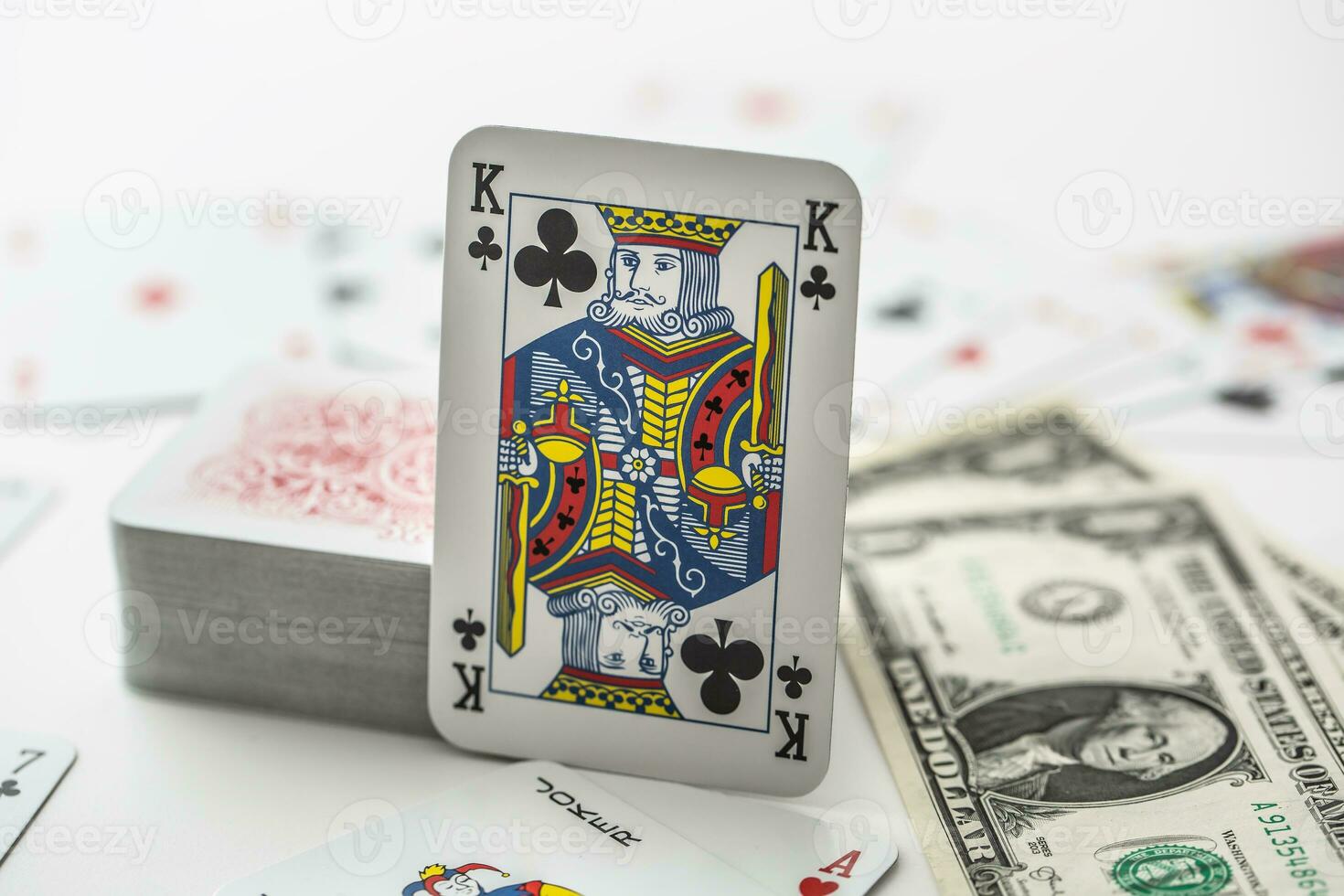 King card with pile of other cards next to a dollar bank notes photo