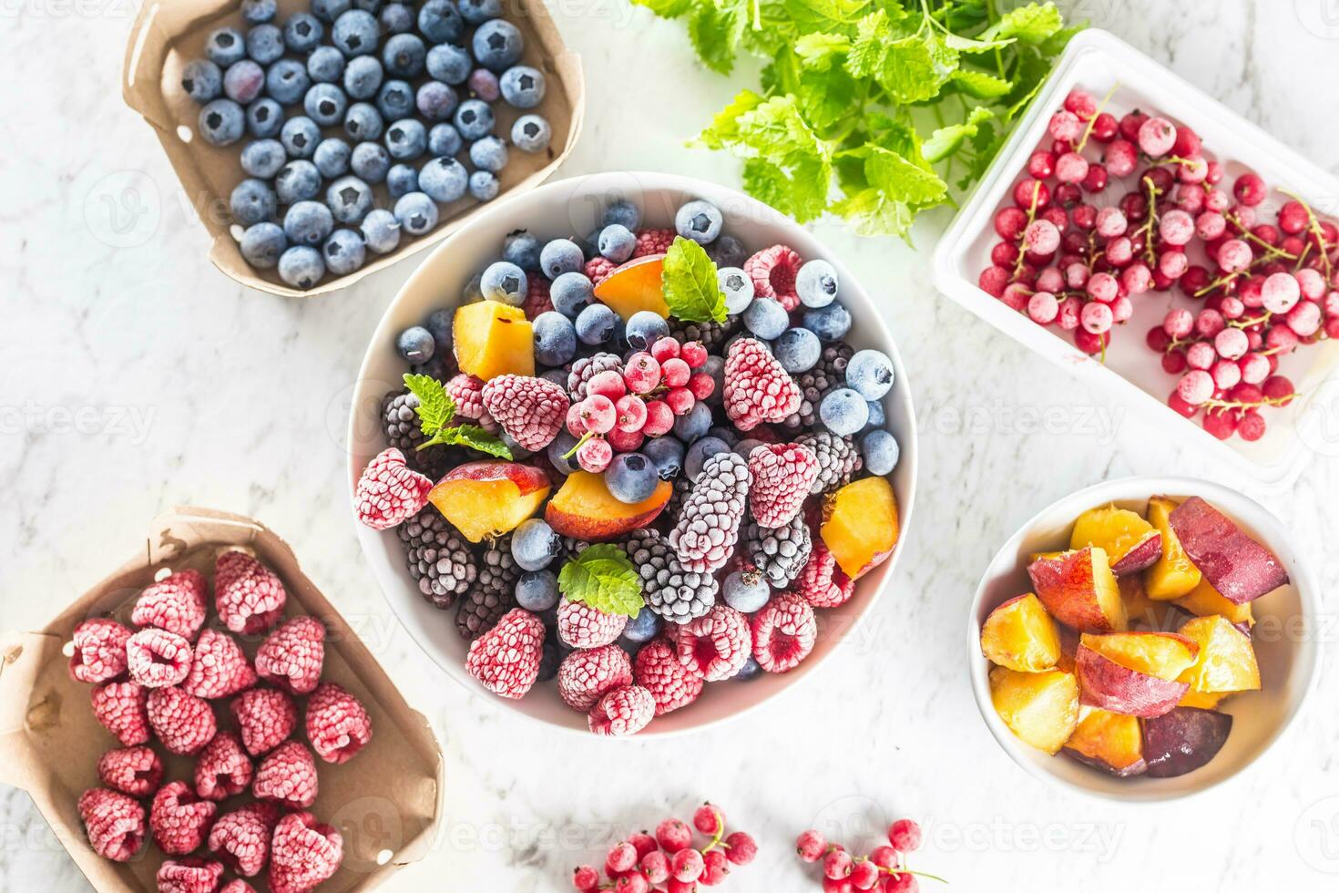Frozen fruits blueberries blackberry raspberry red currant peach and herbs melissa photo