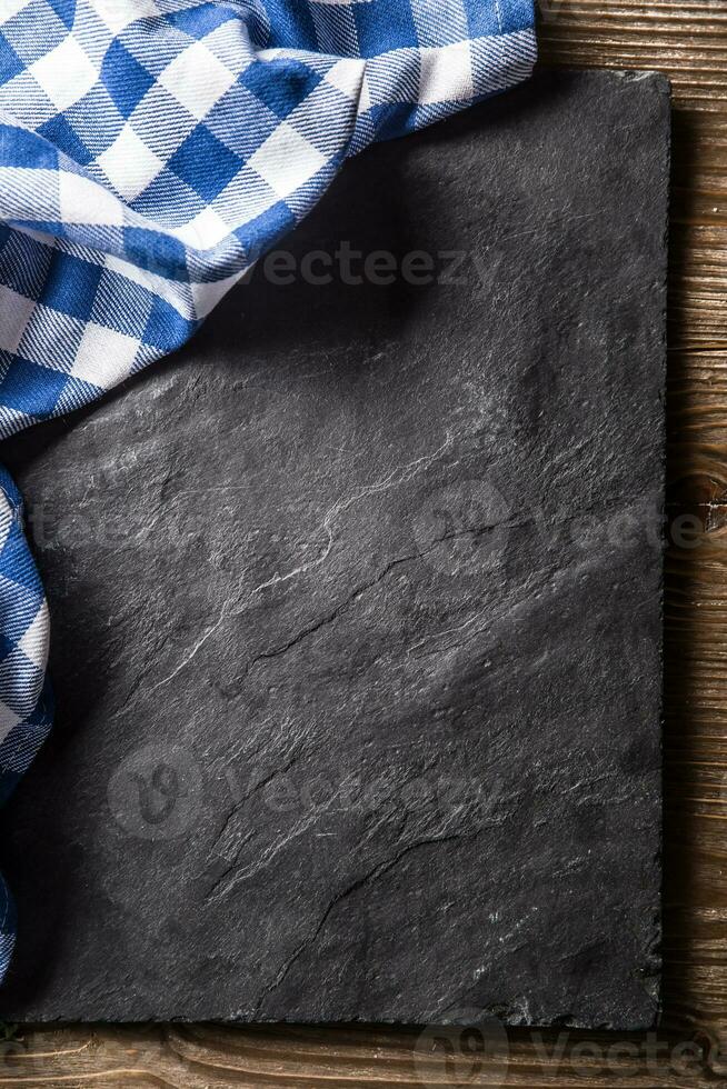 Top of view blue checkered tablecloth on black slate board photo