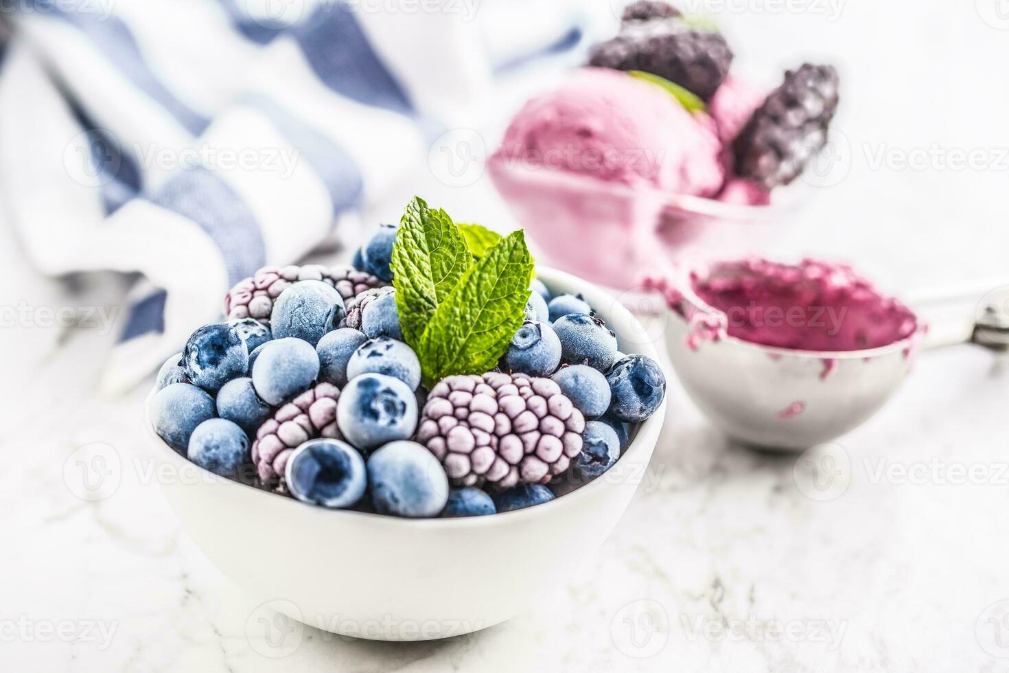Close-up frozen blueberries and blackberries and icecream with mint leaves photo