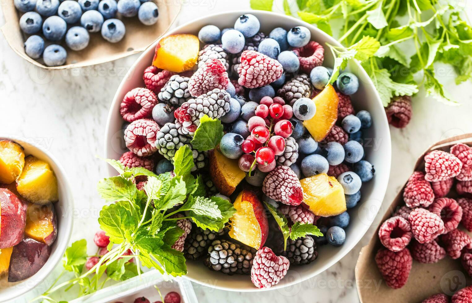 Frozen fruits blueberries blackberry raspberry red currant peach and herbs melissa photo
