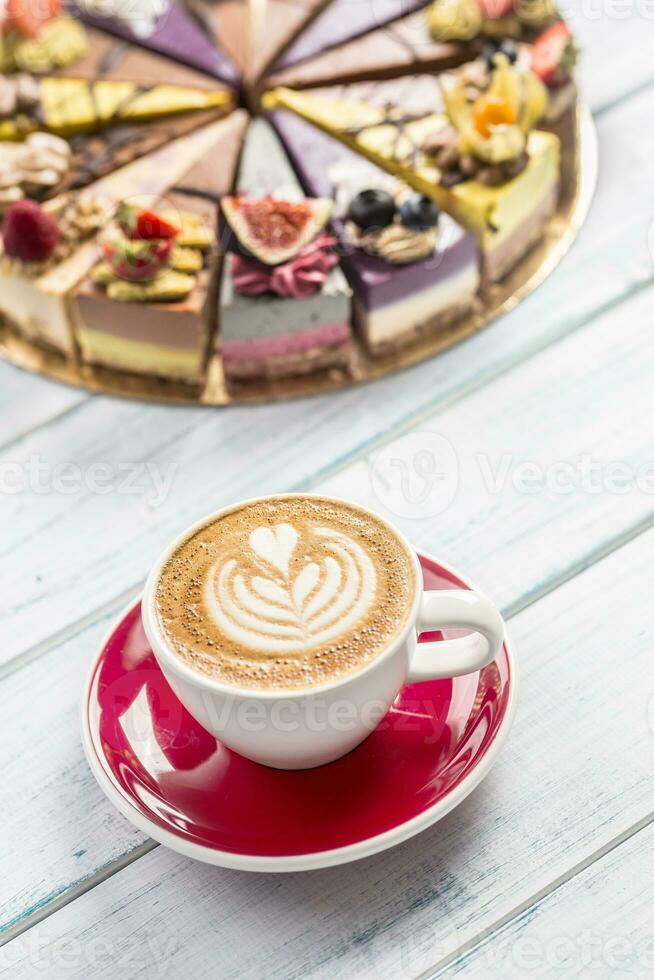 A cup of art coffee cappiciino and mini raw cakes photo