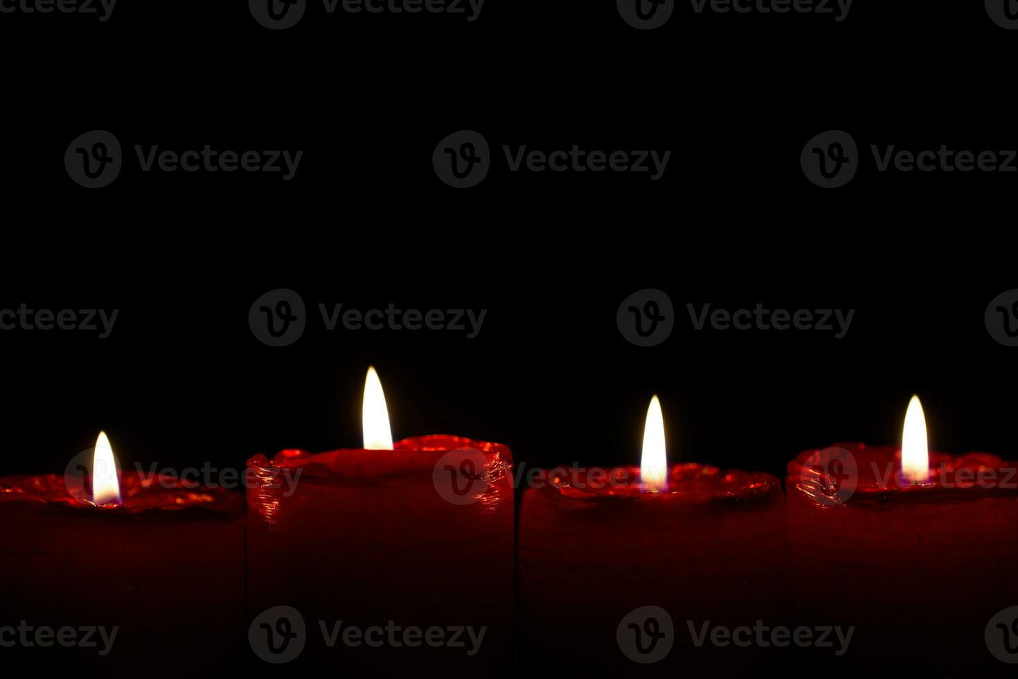 Advent set of four red christmas candles with little flames burning calmly photo