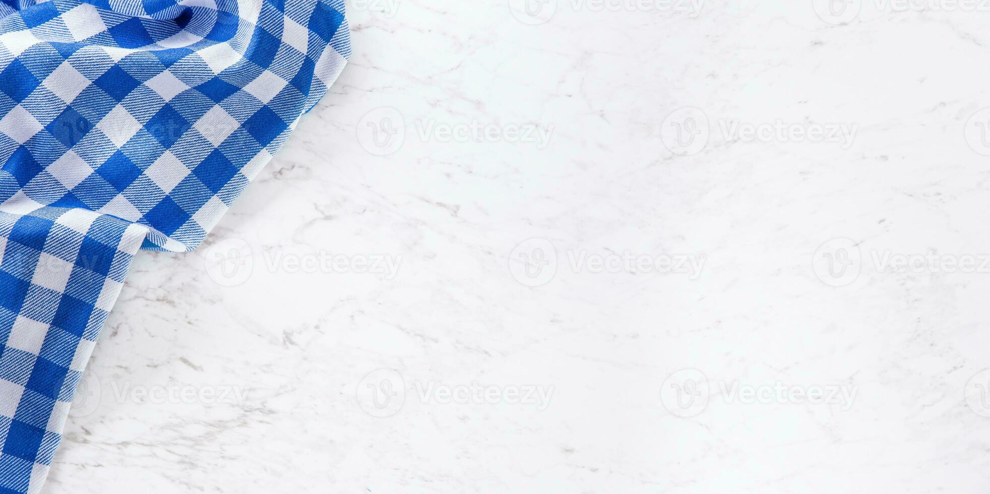 Top of view blue checkered tablecloth on white marble table. photo