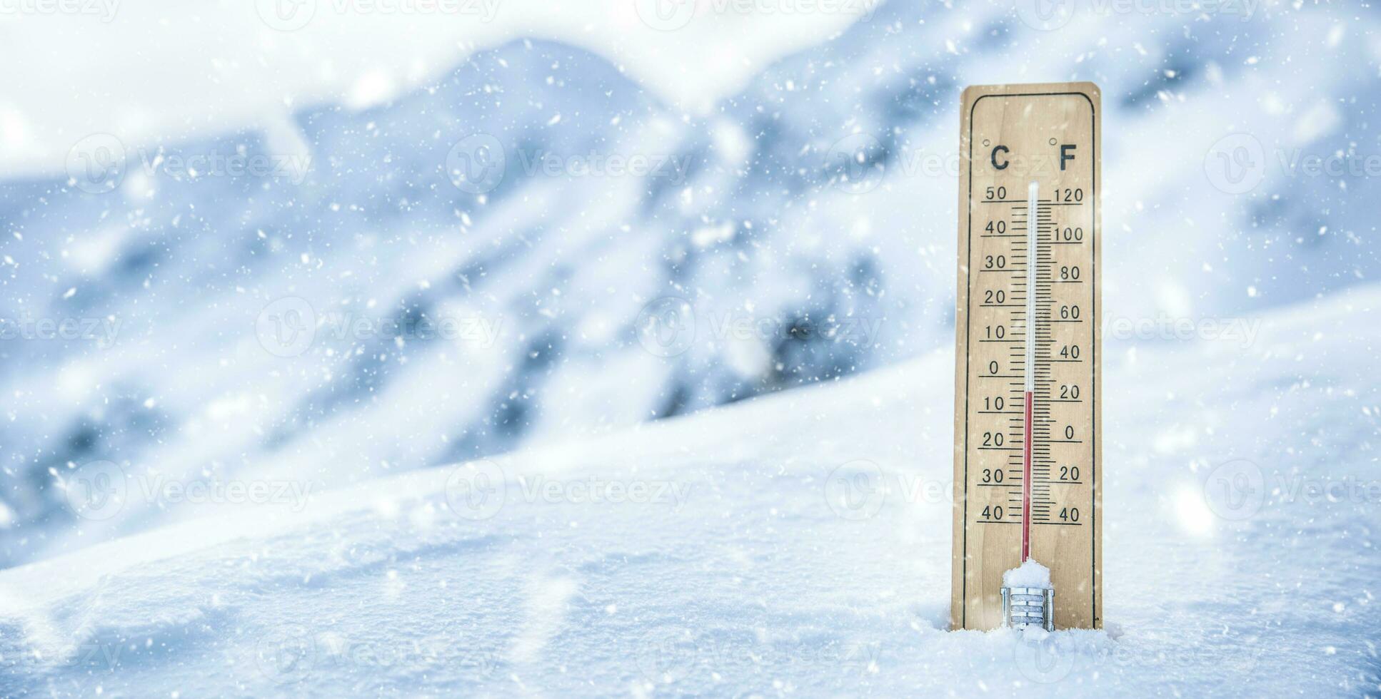 Thermometer on the mountains in the snow shows temperatures below zero. Low temperatures in degrees Celsius and fahrenheit in snowy weather photo