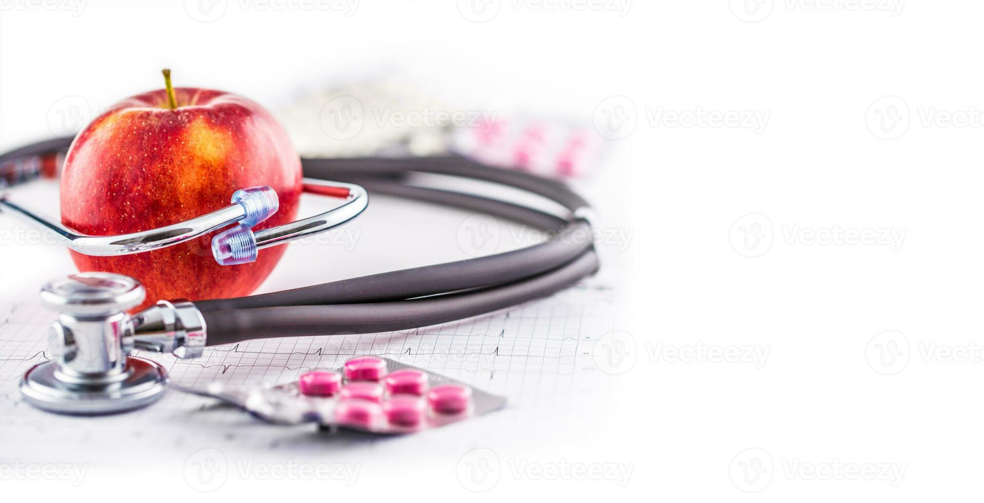 Stethoscope apple and pills on white background photo