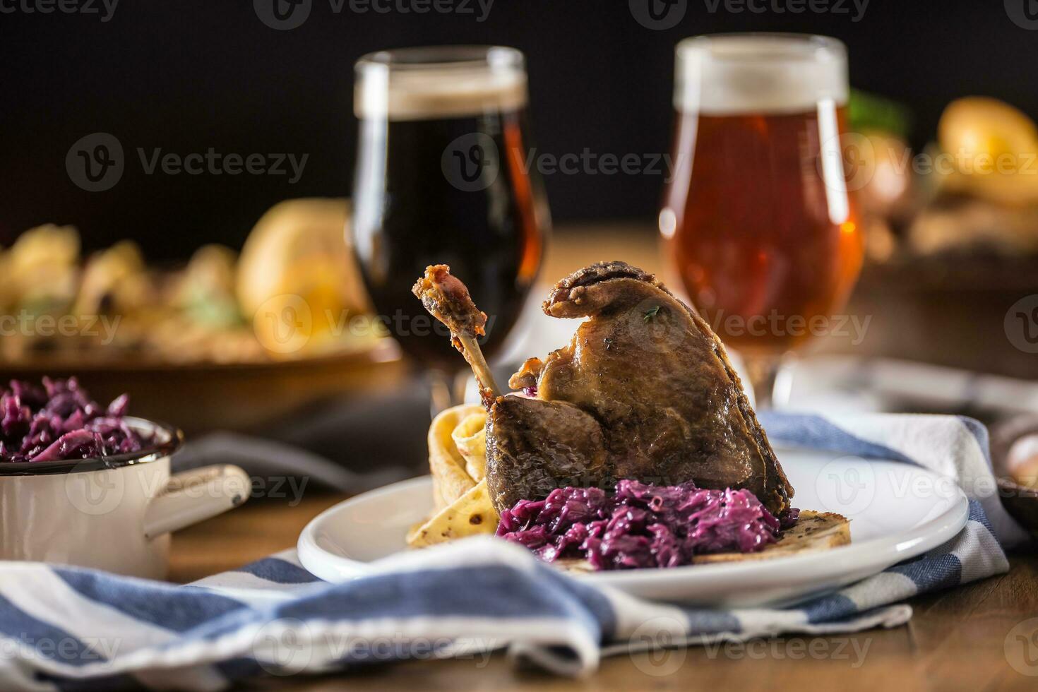 Roasted christmas duck leg red cabbage dumplings liver draft beer and baked buns photo