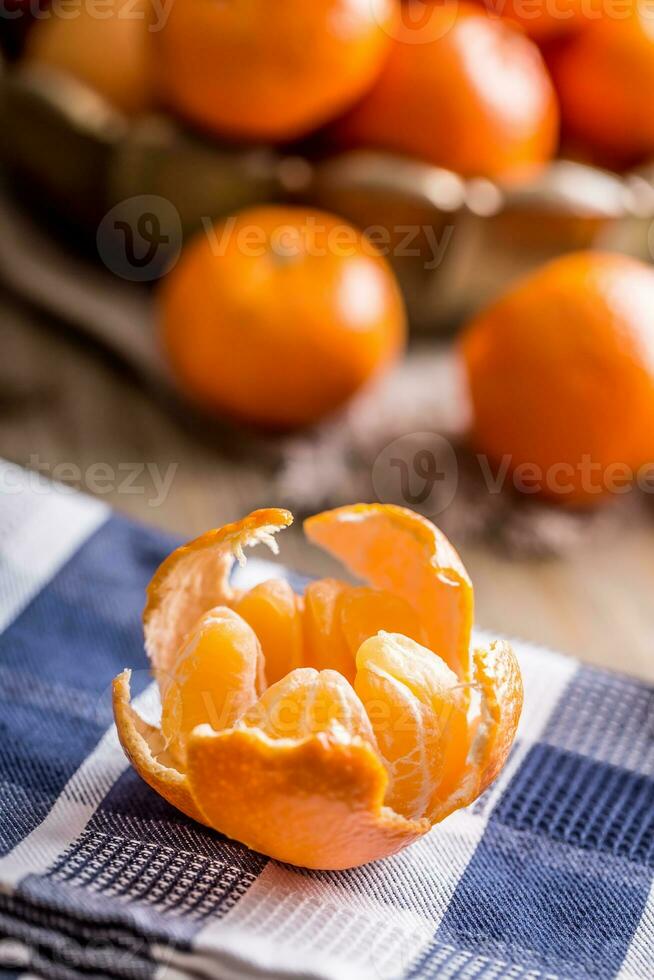 Tangerines, peeled tangerine and tangerine slices on a blue cloth. Mandarine juice photo