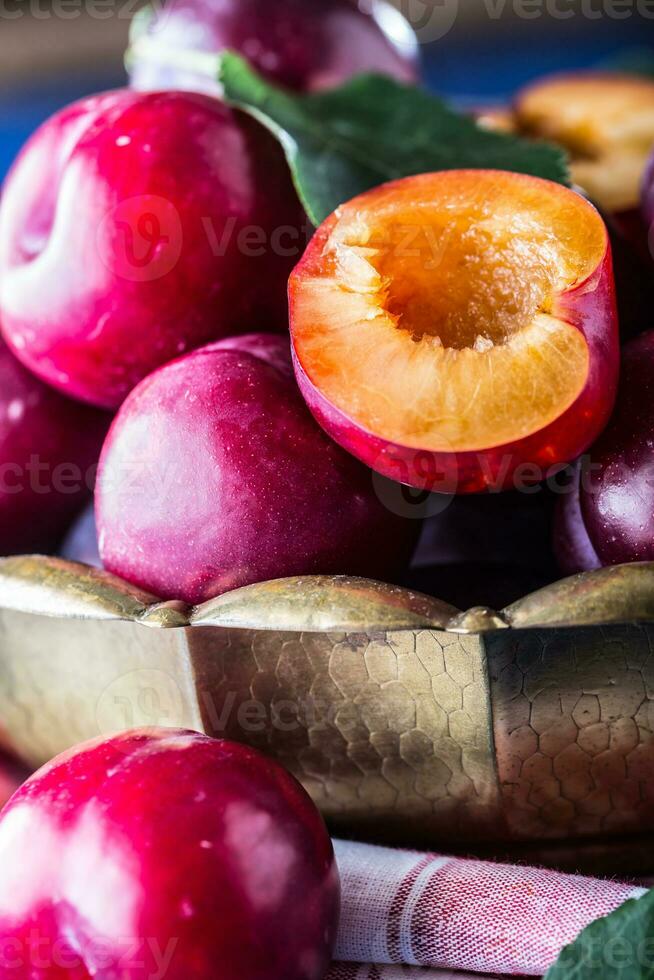 ciruelas Fresco jugoso ciruelas en un cuenco en un de madera o hormigón tablero foto