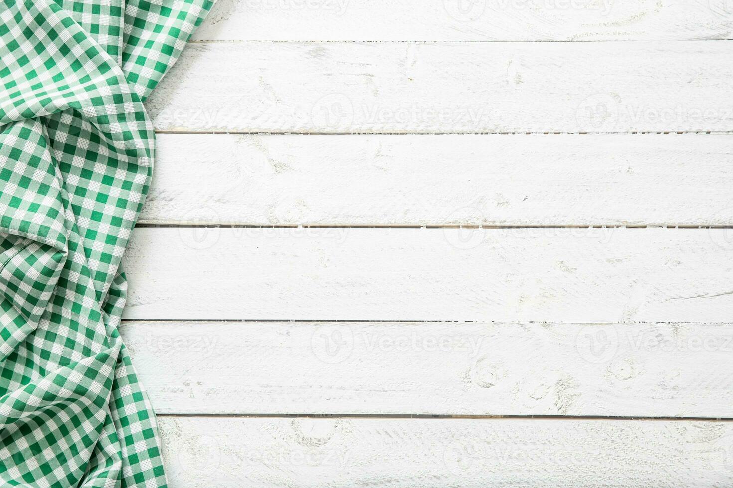 Green checkered kitchen tablecloth on wooden table photo