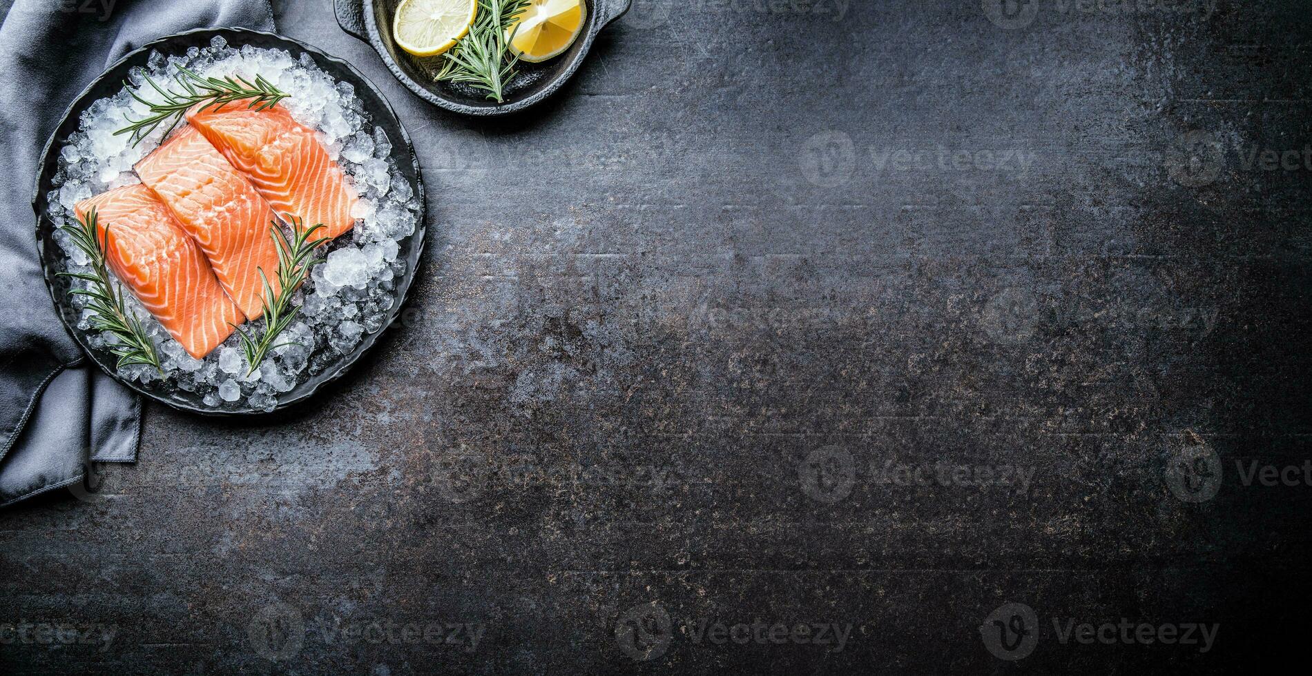 Portioned raw salmon fillets in ice on plate with lemon and rose photo