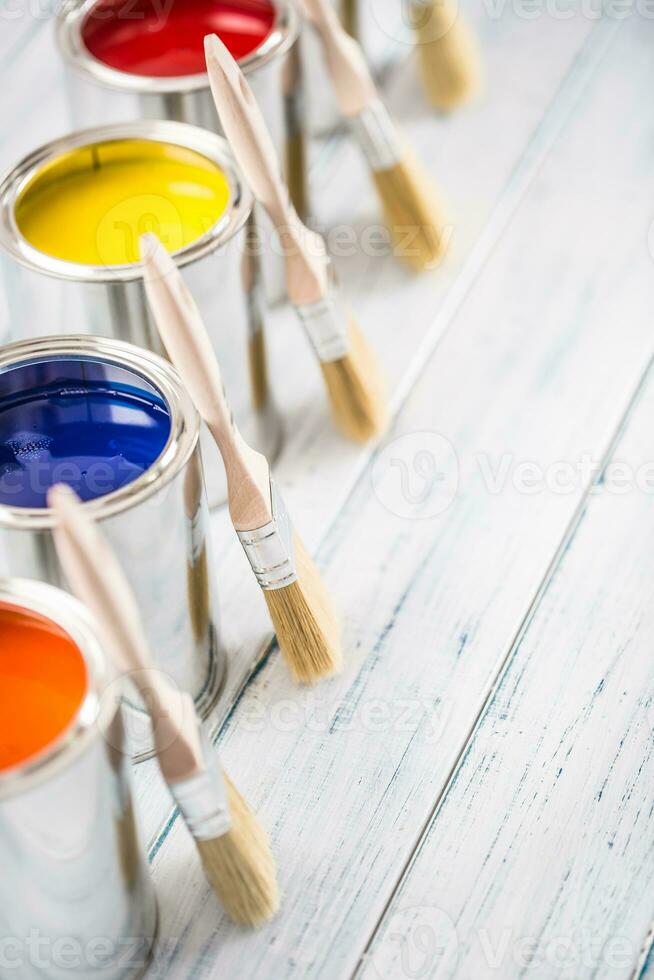 Close-up brushes lying on multicolored paint cans. photo