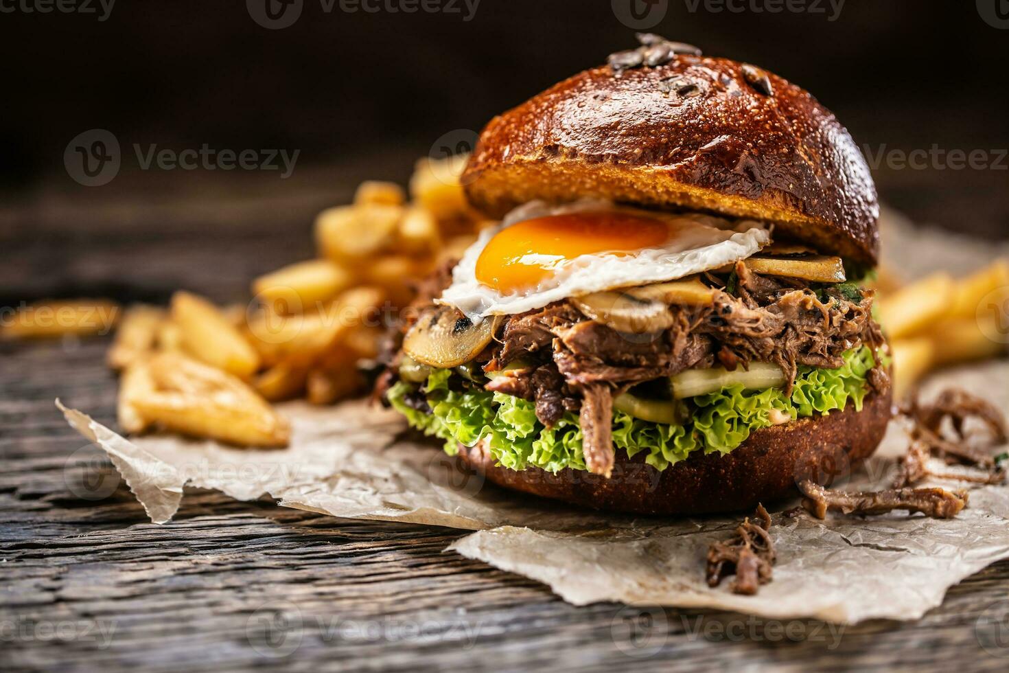 Burger stuffed with shredded confit turkey egg mushrooms and french fries photo