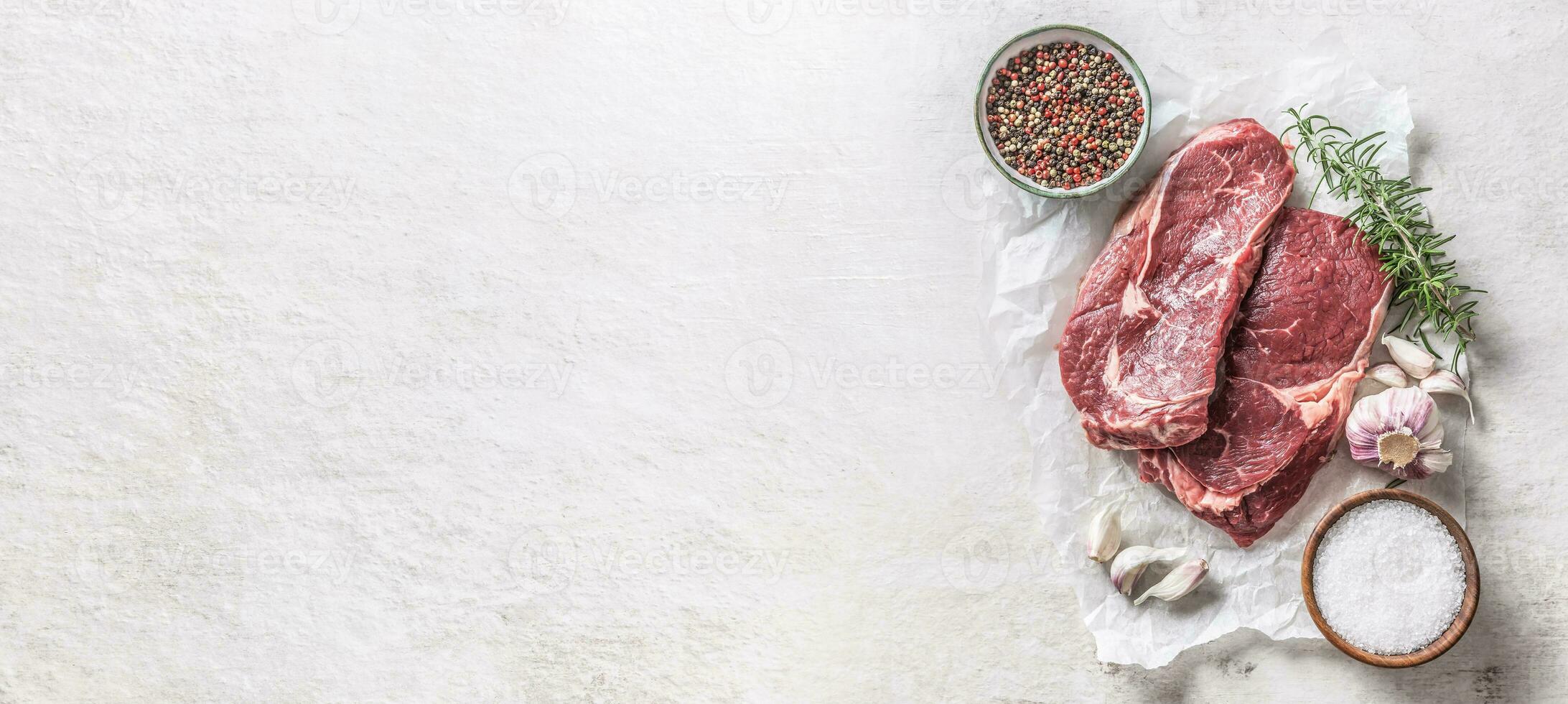 dos costilla ojo filete sal especias Romero y ajo parte superior de vista. carne de vaca carne en blanco hormigón mesa foto