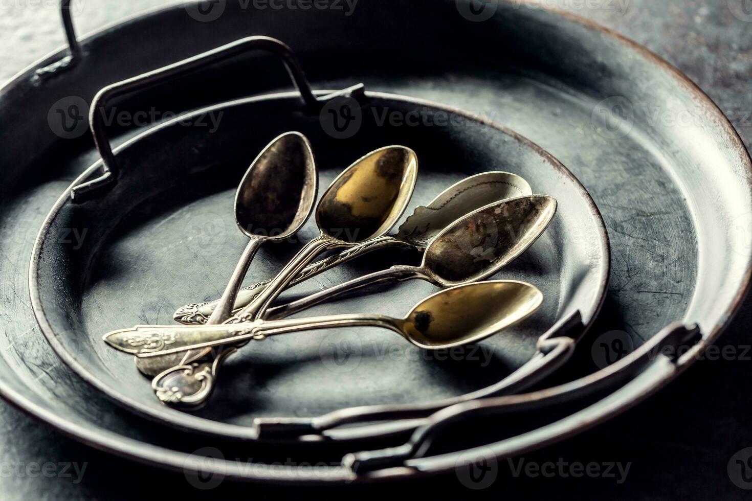 Antique trays with spoons on a rustic table photo