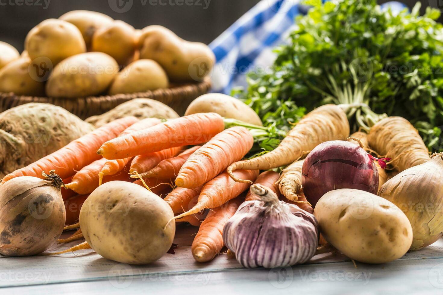 Assortment of fresh vegetables on wooden table. Carrot parsnip garlic celery onion and kohlrabi photo