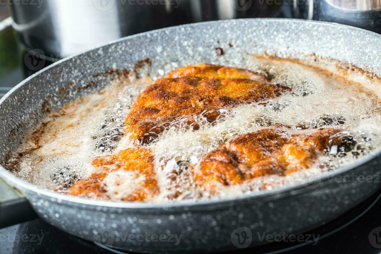 Pan with fried schnitzels in frying oil. photo