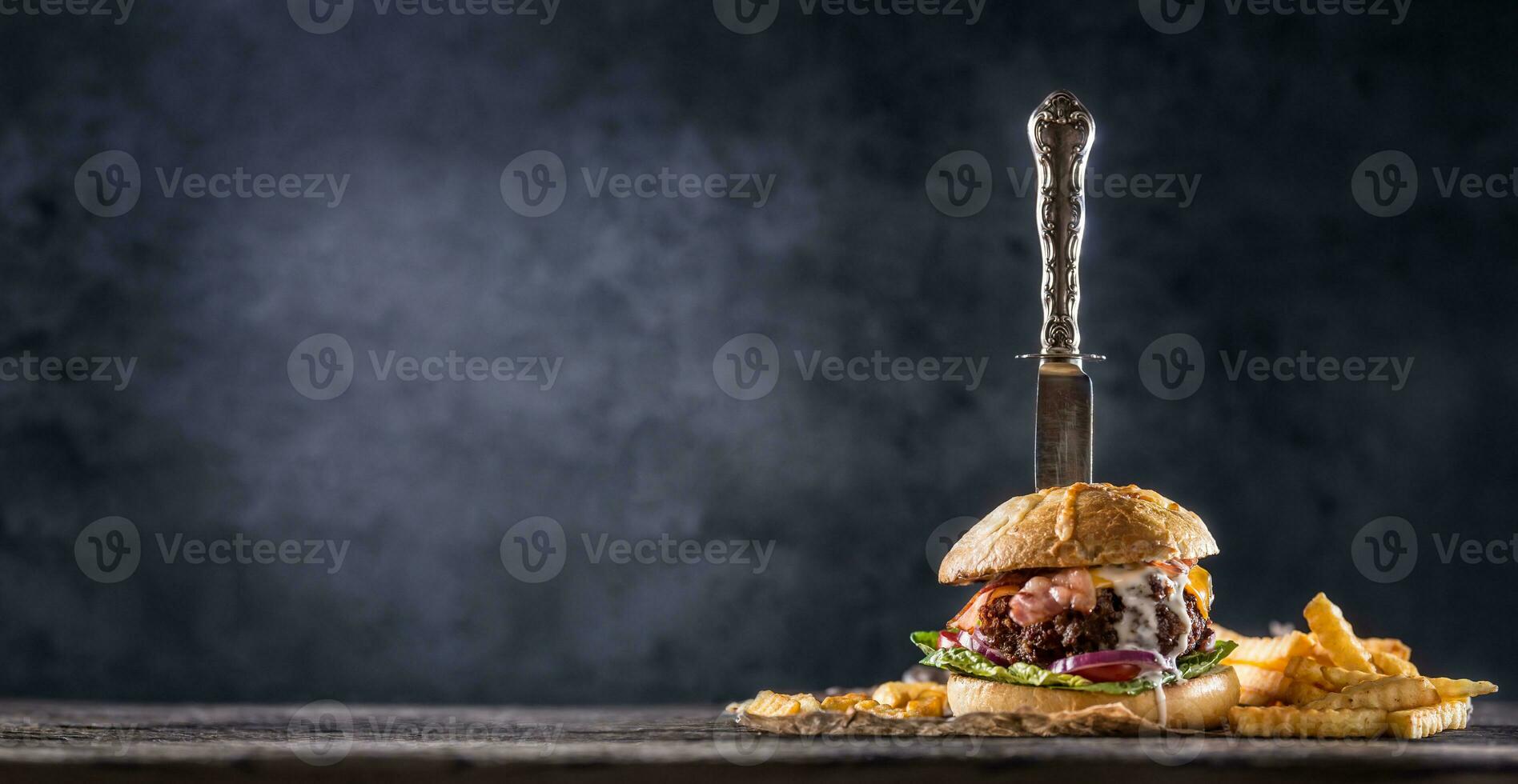 de cerca hogar hecho carne de vaca hamburguesa con cuchillo y papas fritas en de madera mesa foto