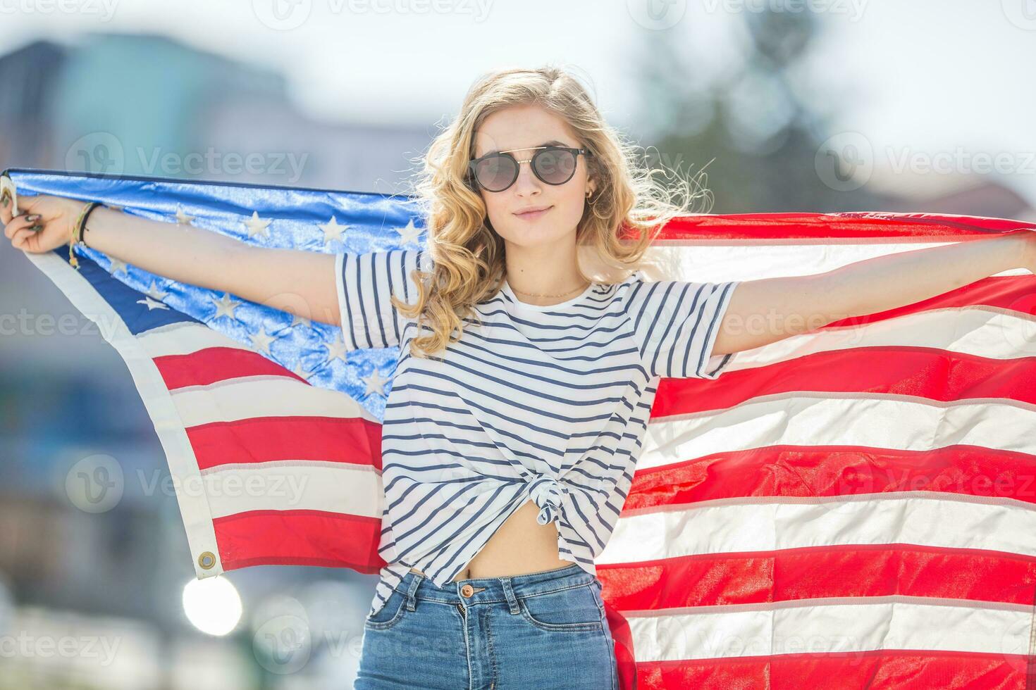 atractivo contento joven niña con el bandera de el unido estados de America foto