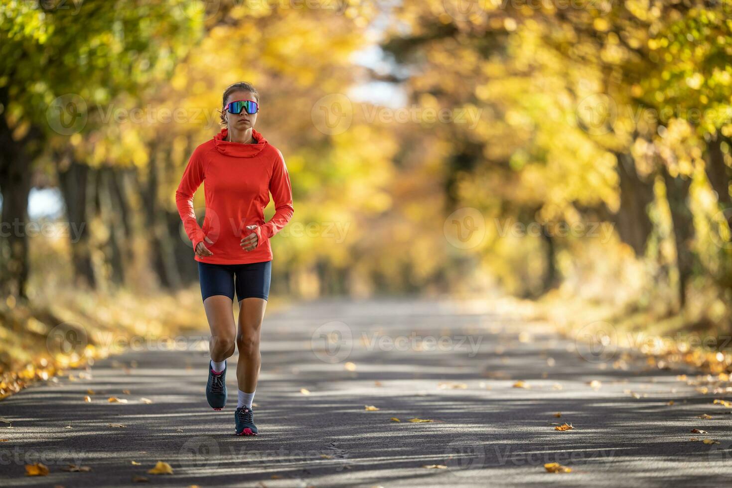 joven hembra atleta en ropa de deporte carreras en el parque durante calentar indio verano foto