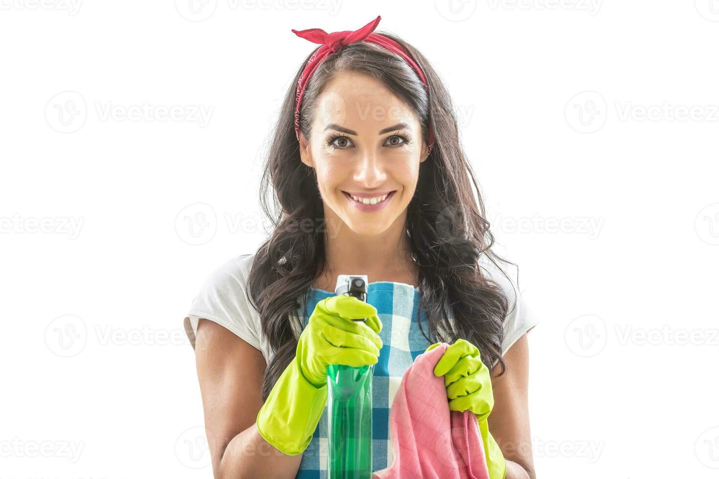joven ama de casa en aislado antecedentes señalando detergente a cámara con un limpieza alfombra en el otro mano foto
