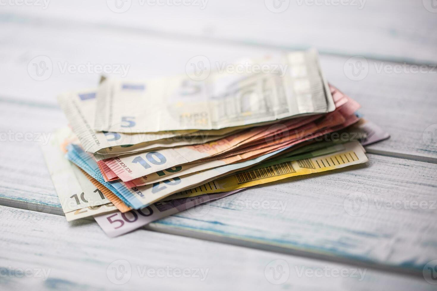 Close-up a pile of banknotes lying on a wooden table. photo