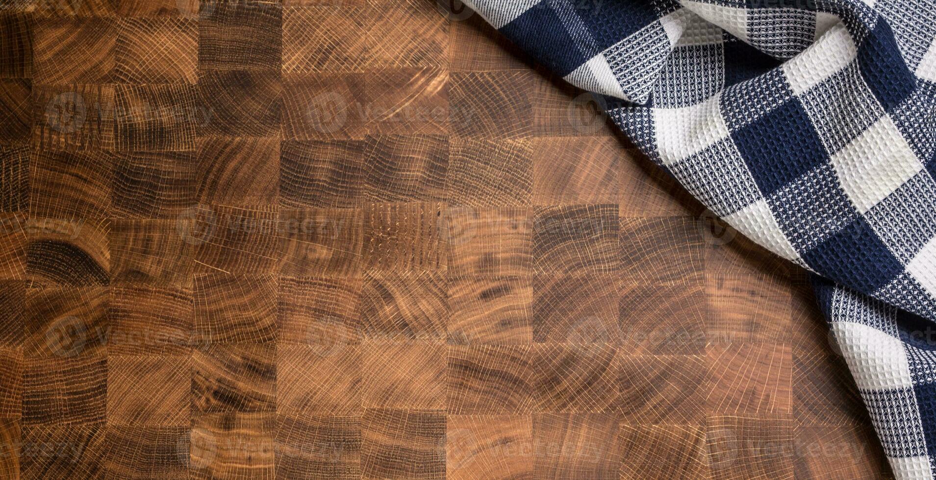 Top  of view checkered tablecloth on empty wooden butcher board photo