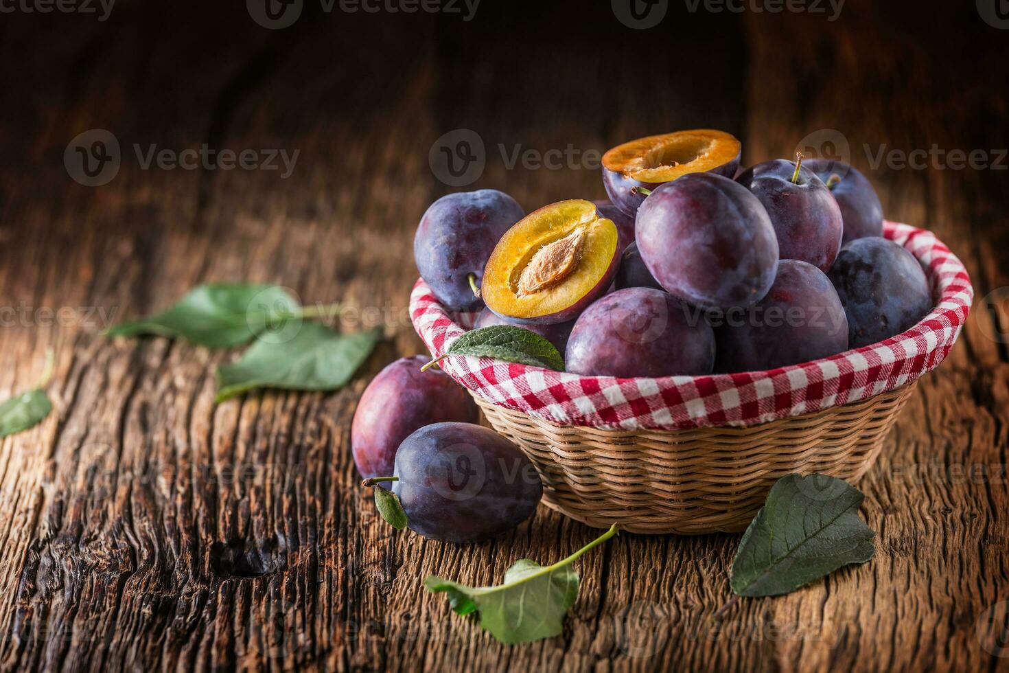 Plums. Fresh juicy plums in a bowl on a wooden or concrete board photo