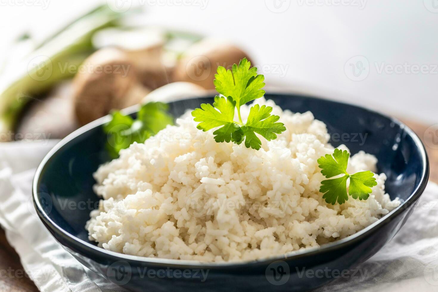 Boiled rice in a blue bowl with coriander. photo