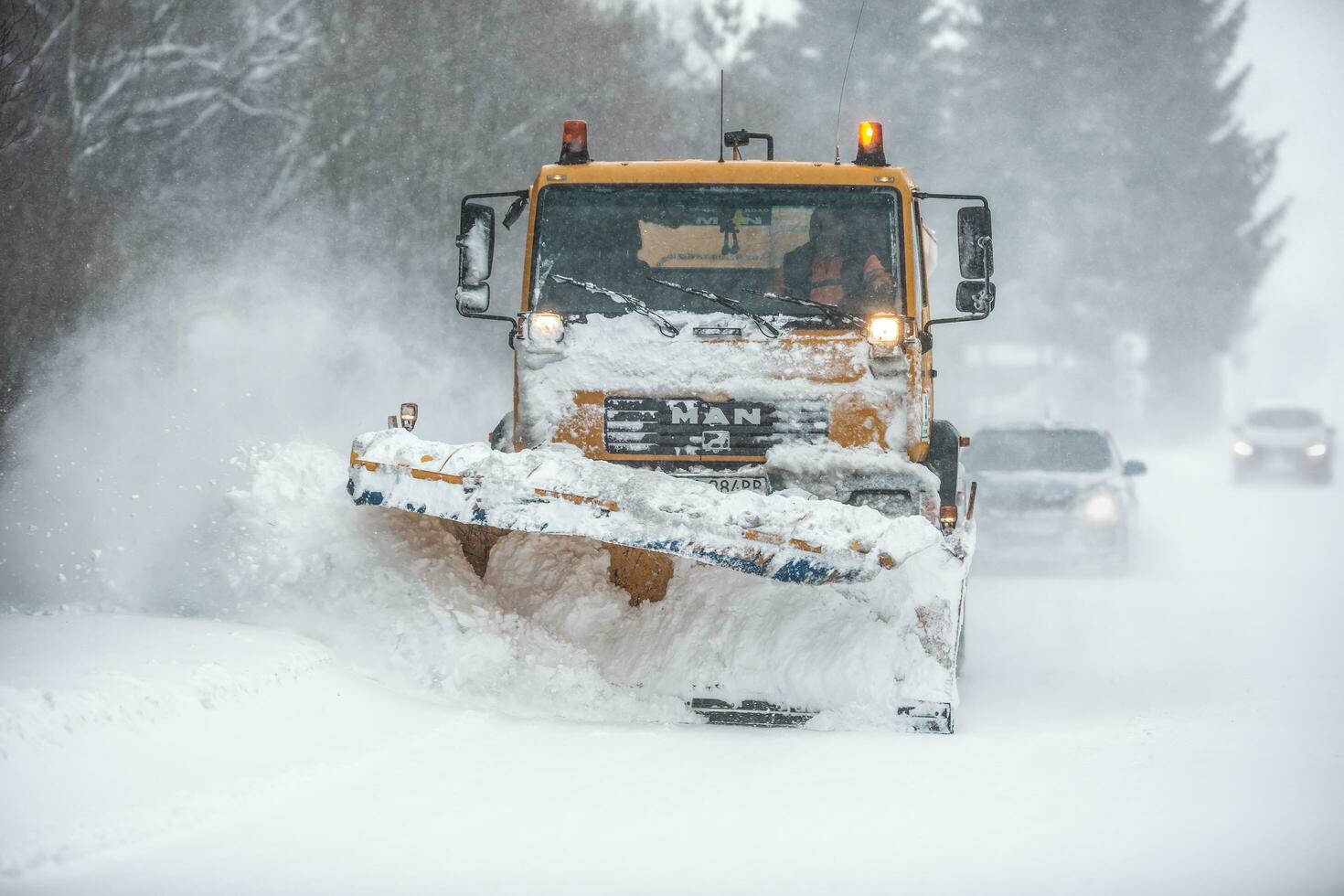Liptov, Slovakia - JANUARY 30, 2022. The snow plow clears the way for the cars behind it photo