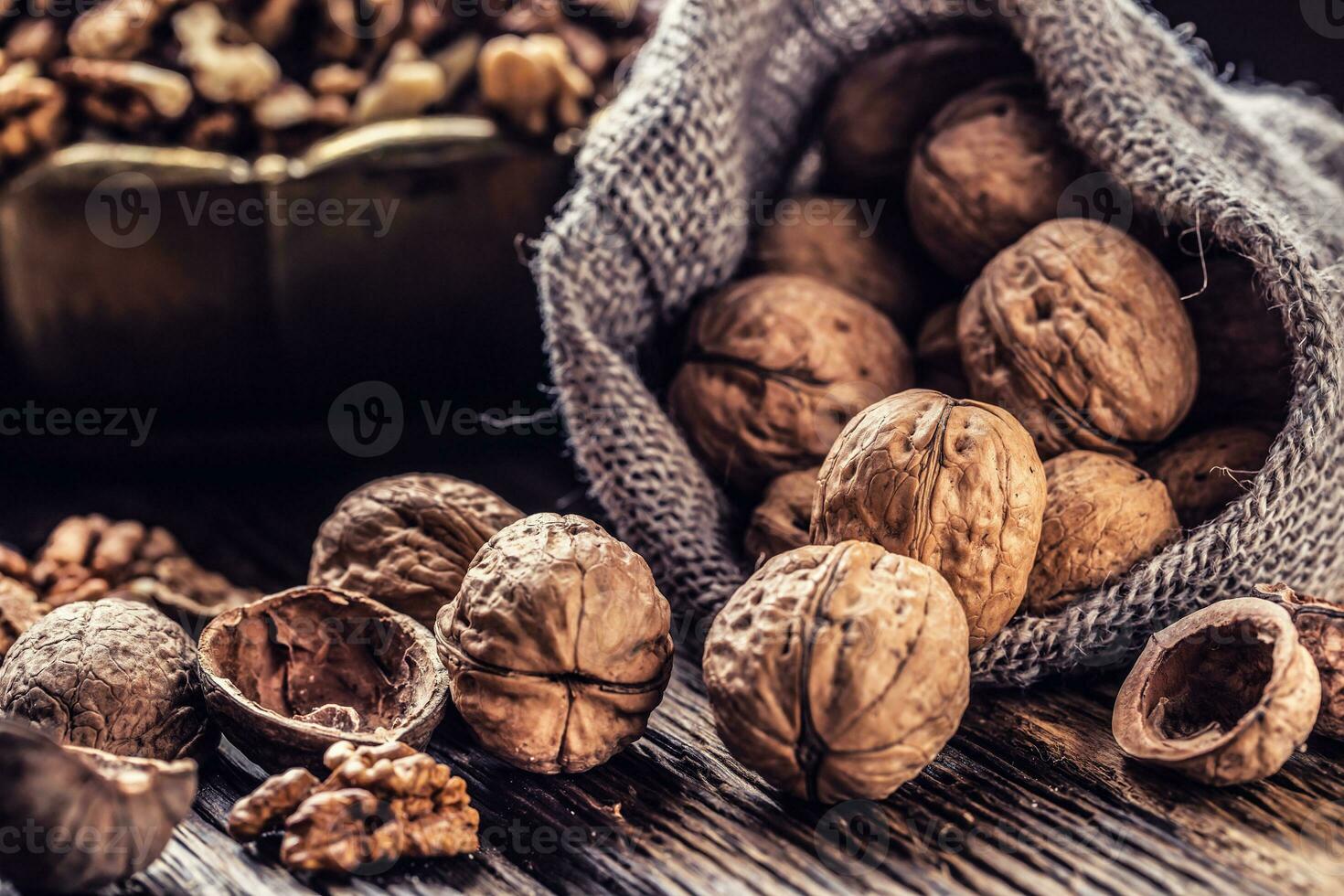 Walnut kernels whole walnuts in burlap sack and vintage bowl photo