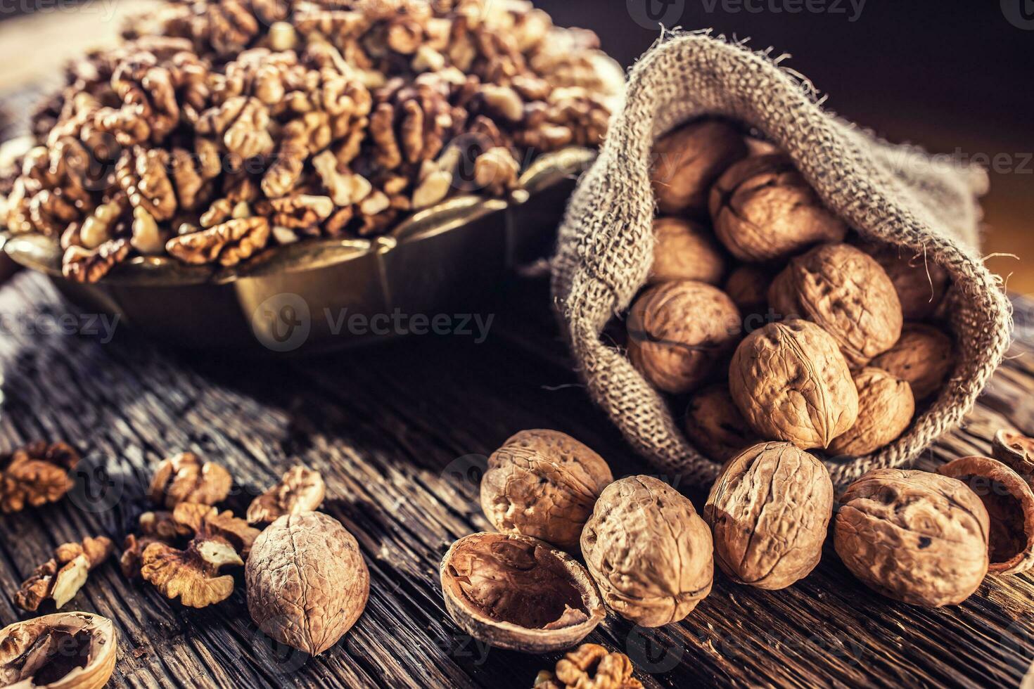 Walnut kernels whole walnuts in burlap sack and vintage bowl photo