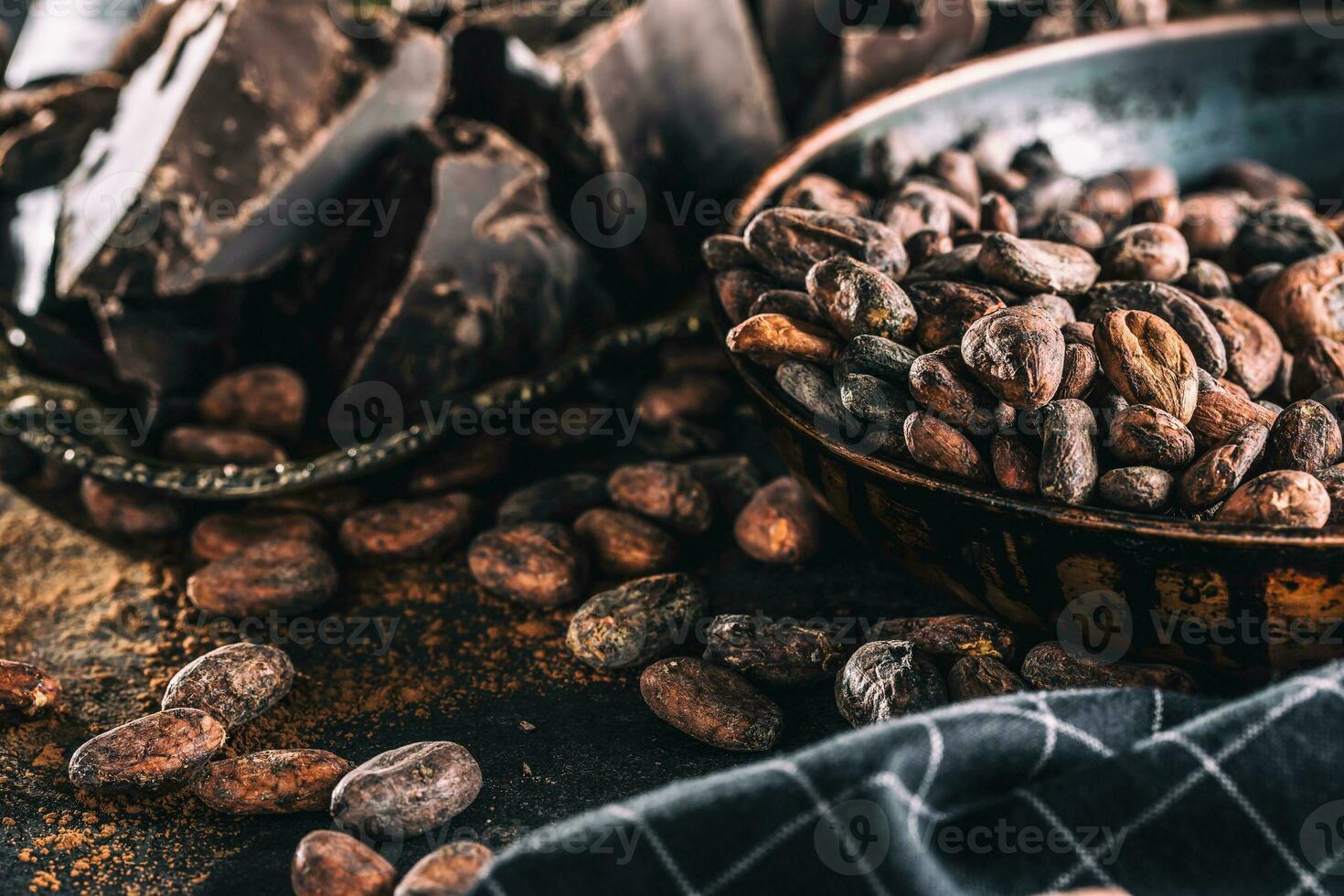 Dark chokolate cocoa beans and powder on concrete table photo