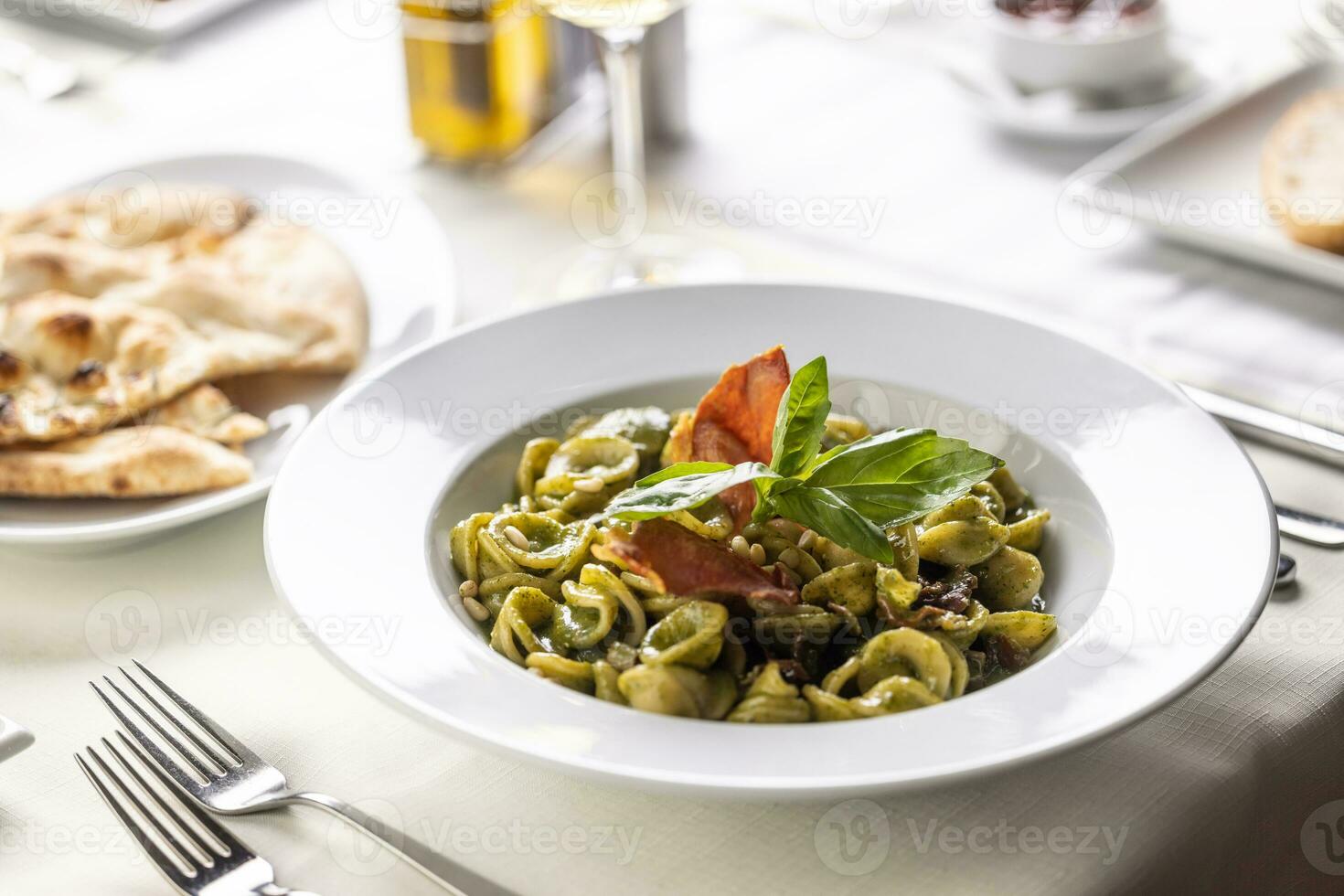 Orecchiette con pesto genovese e speck tirolese, Italian pasta with pesto and Tyrolean bacon photo