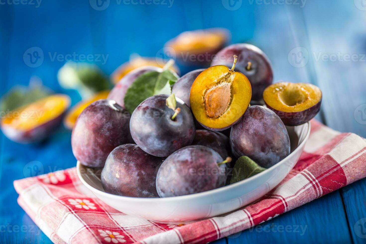 Plums. Fresh juicy plums in a bowl on a wooden or concrete board photo