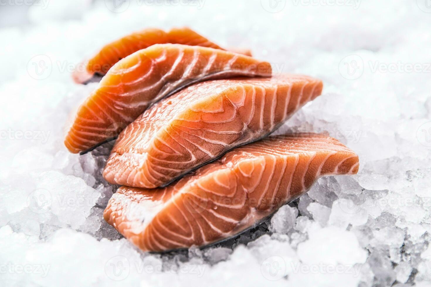 salmón filetes en porciones en hielo y vacío cocina tablero foto