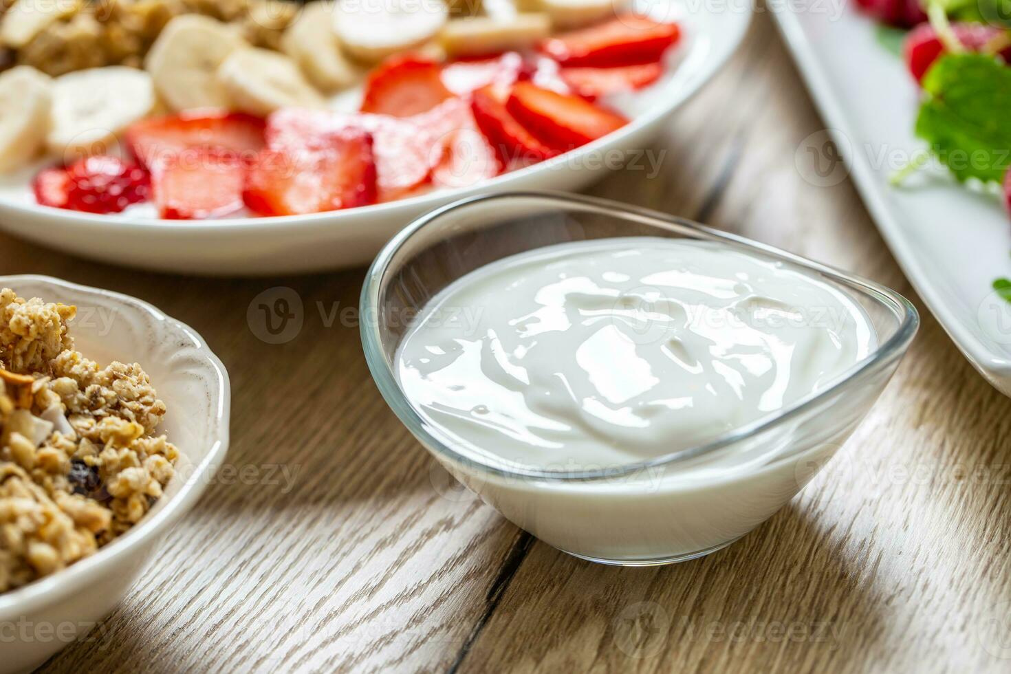 Yogurt in a glass  bowl with healthy breakfast on table photo