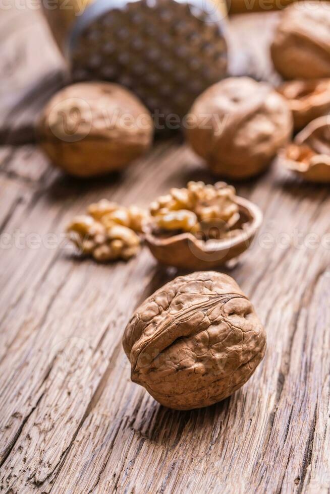 Walnut. Walnut kernels and whole walnuts on rustic old oak table photo