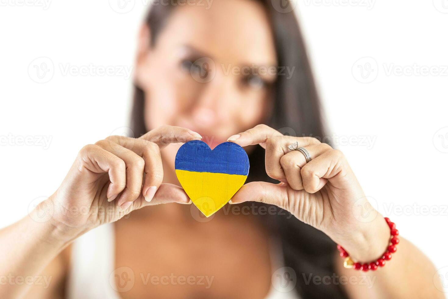 Young activist holding a heart in Ukraine colours representing love and empathy to attacked people. Isolated background photo