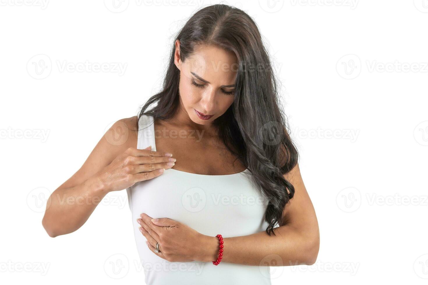 joven mujer checando su senos vistiendo un blanco parte superior y haciendo autoexamen a evitar cáncer. aislado antecedentes foto