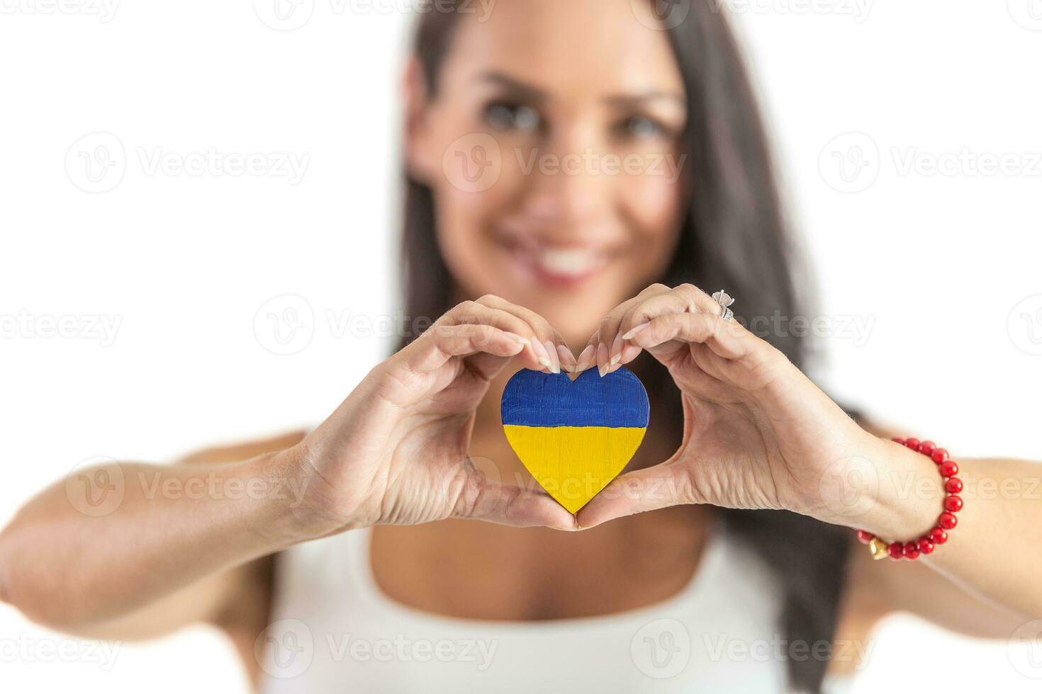 Young activist holding a heart in Ukraine colours representing love and empathy to attacked people. Isolated background photo